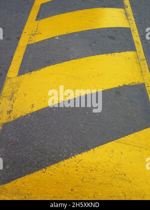 Yellow striped road markings on black asphalt highway. No parking is ...