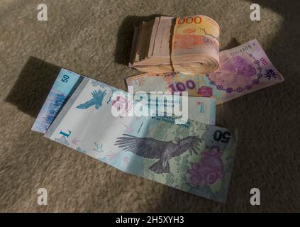 wad of bank notes tied with elastic band with loose notes Stock Photo