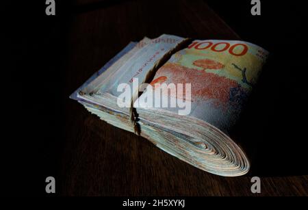 wad of bank notes tied with elastic band Stock Photo