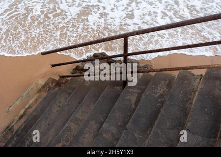 Cement ladder with iron handrail that goes down to Rio Vermelho beach. Salvador Bahia Brazil. Stock Photo