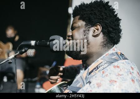 Grayscale portrait of a young black man singing outdoors at night Stock Photo