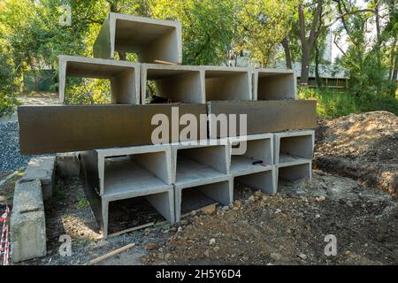 n-shaped concrete blocks for the ditch, for laying utilities stacked on top of each other. Painted with bitumen mastic. Stock Photo