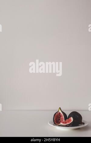 Fresh figs on the plate on grey background. Two figs minimalism. Stock Photo