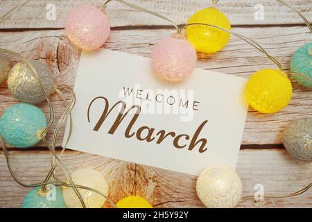 Welcome March card typography text with LED cotton ball on wooden background Stock Photo