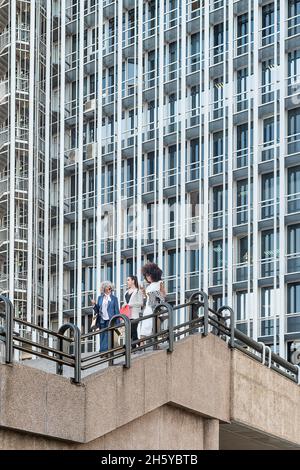 view from below of three female workers on a staircase Stock Photo