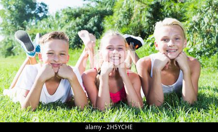 Happy kids laying on grass Stock Photo