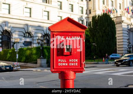Fire alarm red pull box on a city street. Blurred urban background. Stock Photo