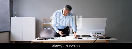 Stealing Trade Secret. Taking Photo Using Phone At Desk Stock Photo
