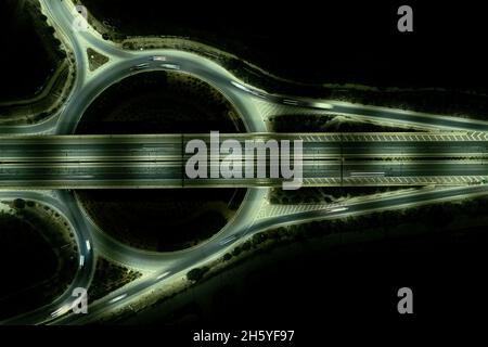 Aerial drone top view of a modern motorway junction roundabout with cars moving. Transportation infrastructure, Stock Photo