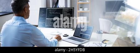 Computer Programmer Writing Program Code On Computer In Office Stock Photo