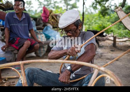 July 2017. Arenesto Deguen making an infant's walker from ratan. Local handicrafts like this add value over simply harvesting the ratan, but are difficult to market and capitalize on without a better distribution system. Aborlan, Barangay Sagpangan, Palawan, Philippines. Stock Photo