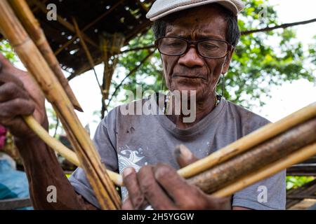 July 2017. Arenesto Deguen making an infant's walker from ratan. Local handicrafts like this add value over simply harvesting the ratan, but are difficult to market and capitalize on without a better distribution system. Aborlan, Barangay Sagpangan, Palawan, Philippines. Stock Photo