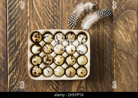 rustic background. quail small eggs in a box in cells with feathers. top view. a copy of the space Stock Photo