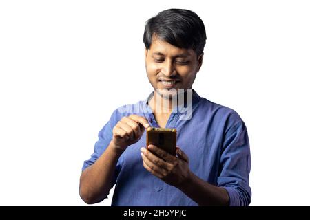 A young Indian male in blue dress using smart phone on white background Stock Photo