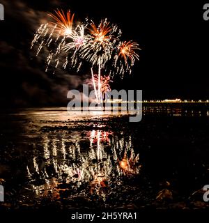 East Beach, Worthing, UK. 5 November 2021.  Fireworks are set off of Worthing Pier and reflect in the incoming tide  Worthing Lions Fireworks. . Picture by Julie Edwards./Alamy Live News Stock Photo