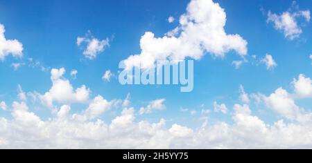 Blue and cyan gradient coloured sky and white clouds floating on air. Astonishing view of harmony of cumulus and clear sky. Stock Photo
