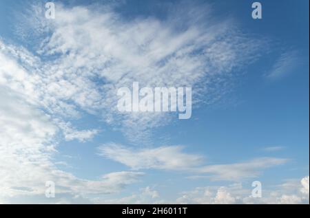 Blue and cyan gradient coloured sky and white clouds floating on air. Astonishing view of harmony of cumulus and clear sky. Stock Photo