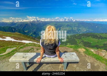 Backside of a tourist girl on top of Cable car station of Plessur Alps in Grisons Canton of Switzerland. Aroser Weisshorn peak Stock Photo