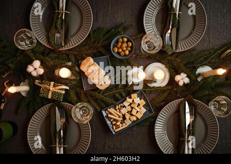 Top view background image of black table setting decorated for Christmas with candles lit, copy space Stock Photo