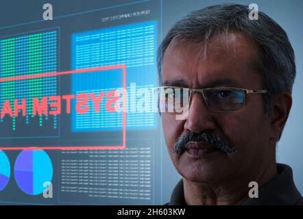 A man's face with a grave expression and cyber hack security system screen behind. Stock Photo