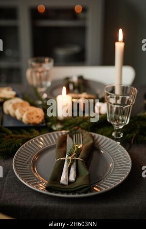 Vertical background image of black table setting decorated for Christmas with candles lit, copy space Stock Photo