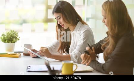 Busy businesswoman, colleague working and planning project use digital tablet computer at office. Stock Photo