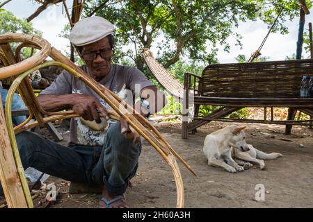 July 2017. Arenesto Deguen making an infant's walker from rattan. Local handicrafts like this add value over simply harvesting the ratan, but are difficult to market and capitalize on without a better distribution system. Aborlan, Barangay Sagpangan, Palawan, Philippines. Stock Photo