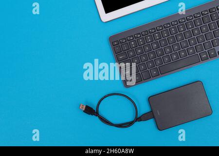 Office Workplace with Digital Gadgets Lying on Blue Table - Flat Lay Stock Photo