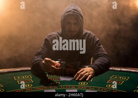 Portrait of a professional poker player sitting at pokers table Stock Photo