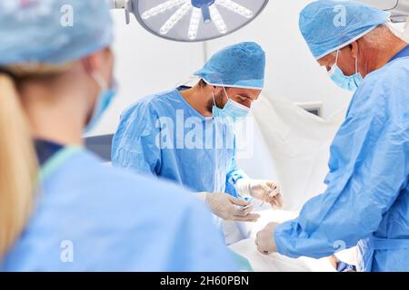 Surgery team of doctors concentrate on performing surgery on a patient Stock Photo