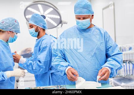 Doctors team in protective clothing preparing an operation in the accident clinic Stock Photo