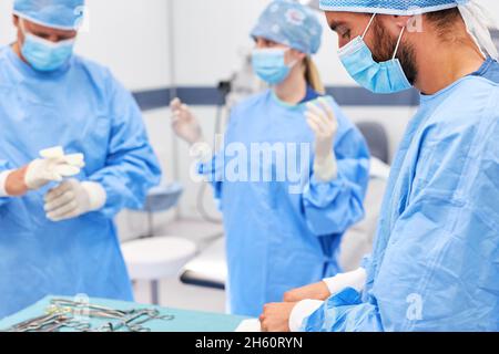 Surgery medical team in sterile protective clothing preparing for an operation