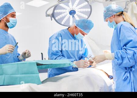 Senior physician and team during a strenuous emergency operation in the surgery department of the trauma clinic Stock Photo