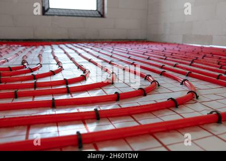 house underfloor heating system installation. red plastic pipes Stock Photo