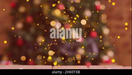 Image of christmas golden dots over blurred christmas tree in background Stock Photo