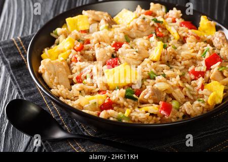 Peruvian fried rice with chicken, omelet, peppers and onions close-up in a bowl on a wooden table. horizontal Stock Photo