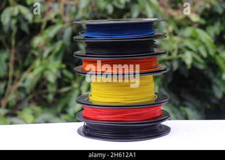 Stack of plastic filaments in a spool used for rapid prototype manufacturing methods or 3D printing Stock Photo