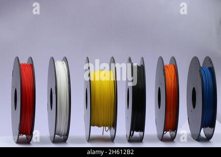 PLA filaments is one of the 3d printing materials, Coils of different color plastic filaments isolated on white Stock Photo