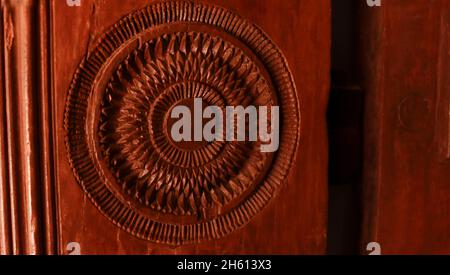 Brown wood is a circular pattern carved into wood in the door Stock Photo