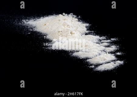 Sprinkled wheat flour splash spots on a black background Stock Photo