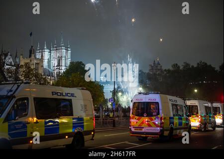 LONDON - NOVEMBER 1, 2021: Police vans parked while fireworks set off in Parliament Square during The Million Mask Stock Photo