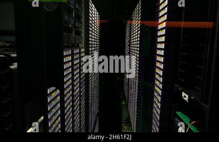 Data center with multiple rows of fully operational server racks Stock Photo