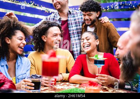 Multicultural people having genuine fun moment at fancy cocktail bar patio - Beverage life style concept with people laughing together on happy hour Stock Photo