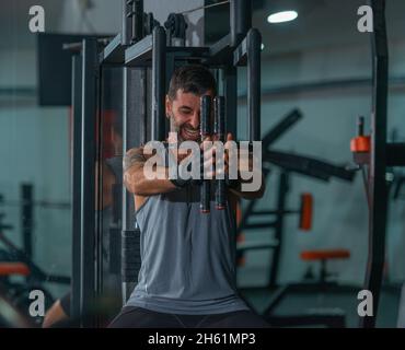 Mature trainer athlete working out chest muscles doing strength training exercises on gym benchpress equipment. Stock Photo