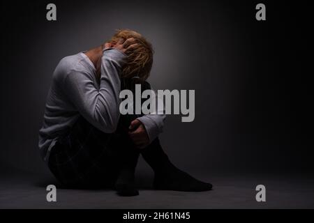 Depressed boy is suffering from the past memories he is thinking about the whole time Stock Photo