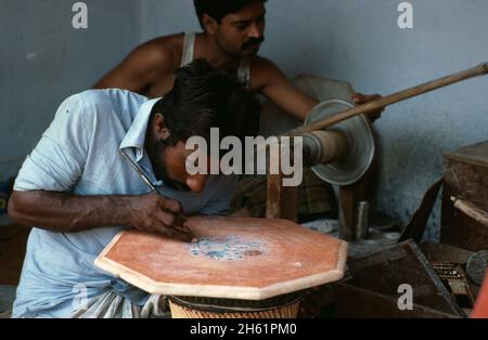 India. New Delhi. Craftworker inlaying decoration on tabletop. Stock Photo