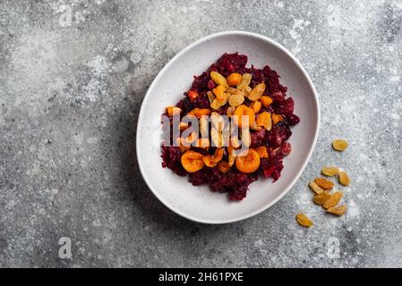 Beetroot salad with prunes in plate vegan food close-up copy space top view Stock Photo