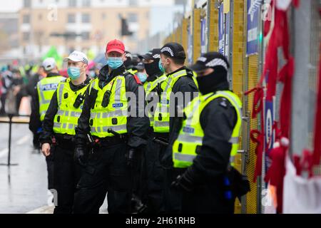 Glasgow, UK. 12th Nov, 2021. Police officers secure the fence to the grounds of the UN Climate Change Conference COP26. In Glasgow, around 200 countries are struggling for two weeks to find a way to achieve the goal of limiting global warming to 1.5 degrees compared to pre-industrial times. Credit: Christoph Soeder/dpa/Alamy Live News Stock Photo