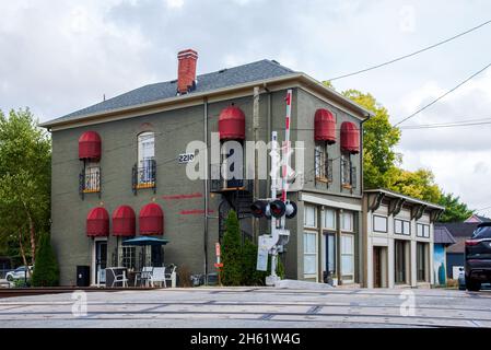 A two-story brick building with red awnings close to the railroad tracks in Southport, Indiana, built in 1870. Stock Photo