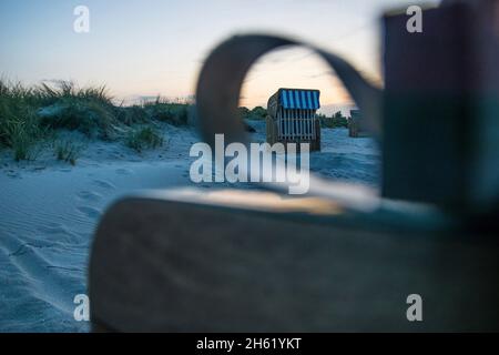 beach chairs in the light of the setting sun on the beach in schoenberg,germany. Stock Photo